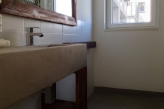 mikrocement w łazience na podłodze oraz blat z umywalką z mikrocementu
